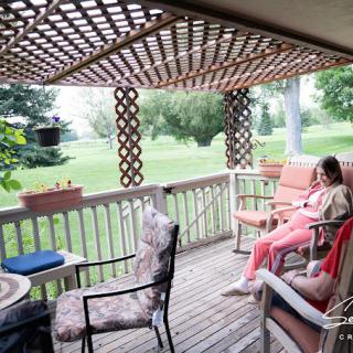 A tranquil porch area with comfortable seating and a view of the greenery.