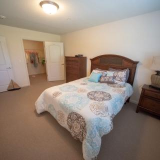 A cozy bedroom with a neatly made bed and wooden furniture.