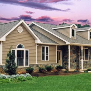 A beautiful suburban house with well-maintained landscaping during sunset.