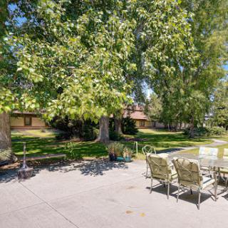 A serene outdoor patio area surrounded by lush greenery, perfect for relaxation and gatherings.