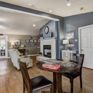A modern living and dining area with hardwood floors, a cozy fireplace, and stylish furniture.