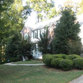 A suburban house with a well-maintained garden and lush greenery.