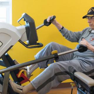 A senior individual using exercise equipment indoors.