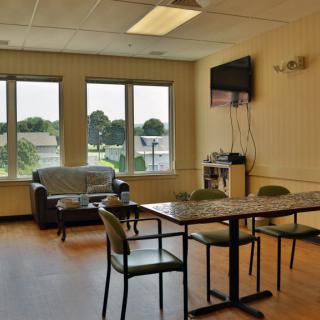 A cozy break room with a table, chairs, and a television.