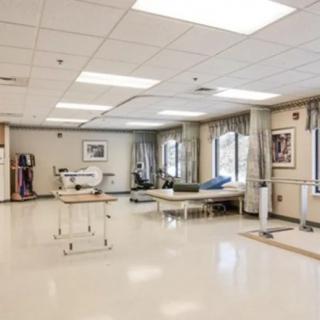 A spacious physical therapy room equipped with exercise equipment and treatment areas.