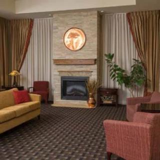 A cozy living room with a central fireplace, surrounded by comfortable seating and elegant decor.