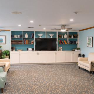 A modern living room with a large television and built-in bookshelves.