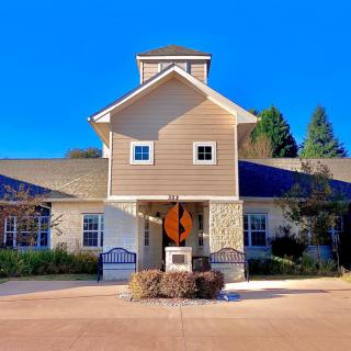 A suburban house with a neatly maintained front yard on a clear, sunny day.
