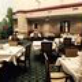 An outdoor restaurant seating area with tables and chairs arranged for dining.