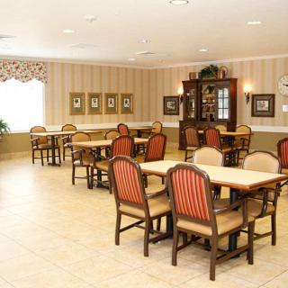 An elegantly furnished dining room with tables and chairs arranged neatly.