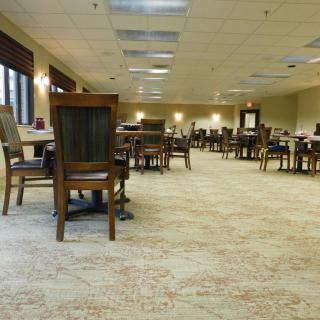 An empty dining room with neatly arranged tables and chairs.