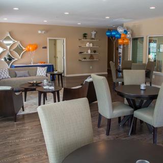 A modern lounge area with comfortable seating and decorative elements, including balloons and wall art.