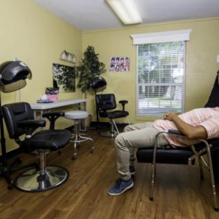 A person relaxing on a chair in a hair salon with yellow walls.