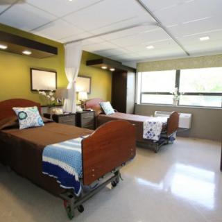 A clean and well-organized hospital room with two beds, designed for patient comfort and care.