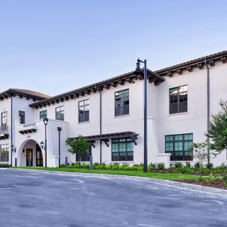 A modern school building with a clean, white facade and black trim.