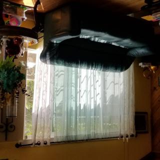 An upside-down view of a living room with a window and sheer curtains.
