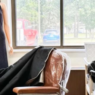 A salon interior featuring a barber chair and mannequin near a large window.