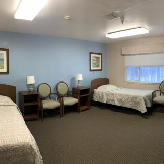 A neat and tidy bedroom with two single beds and simple furnishings.
