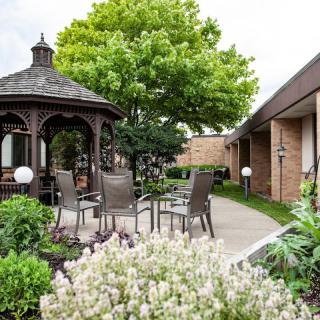 A peaceful garden setting with a gazebo and outdoor seating area.