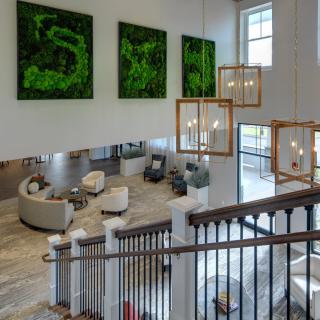 A modern lobby with a spacious seating area, contemporary artwork, and elegant chandeliers.