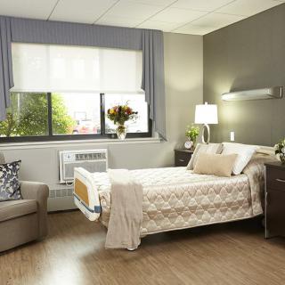 A modern hospital room with a comfortable bed and natural lighting.