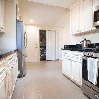 A modern kitchen with white cabinets and stainless steel appliances.