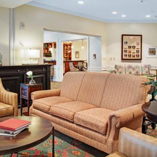 A cozy living room with a sofa, armchairs, and a fireplace.