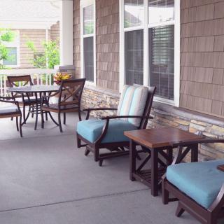 A cozy porch with comfortable seating and tables, perfect for relaxation.