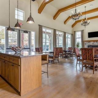 Spacious kitchen and dining area with high ceilings, ample natural light, and elegant chandeliers.