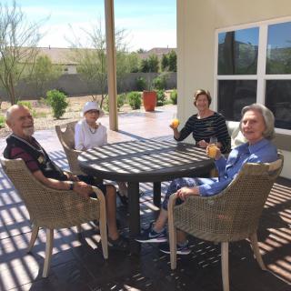 A group of people enjoying a relaxing time together on a sunny patio.