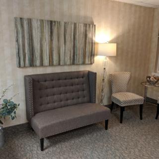 A cozy living room setup featuring a stylish sofa, an elegant chair, and tasteful decor.