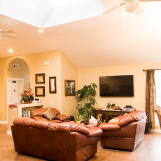 A cozy living room with leather sofas, a large television, and modern decor.