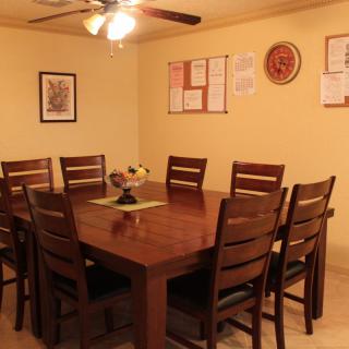 A cozy dining room featuring a wooden table with matching chairs and wall decorations.