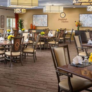 An upscale dining room with neatly arranged tables and chairs, featuring elegant lighting and tasteful decor.