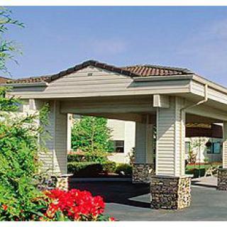 Entrance of a hotel with landscaped surroundings.