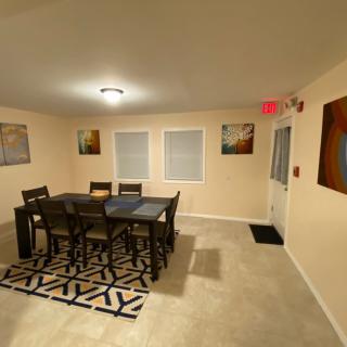 A well-lit dining room with a table set and wall art.