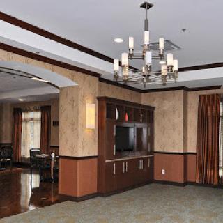 A spacious and elegantly designed living room featuring a stylish chandelier and modern furnishings.