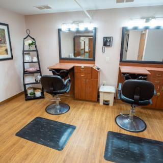 A modern hair salon setup featuring styling chairs and well-lit mirrors.