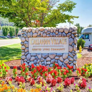 A well-maintained entrance sign surrounded by colorful flowers and greenery.