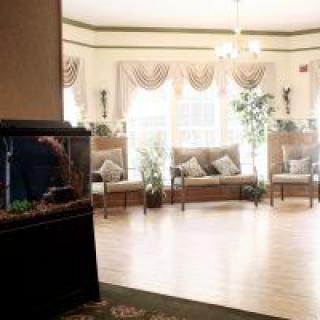 A cozy lobby with an aquarium and comfortable seating surrounded by plants.