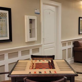 A cozy game room featuring a chess table with elegant wall decorations.