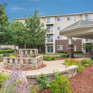 A well-landscaped outdoor area with a pathway leading to an apartment building.