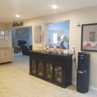 A cozy living room with a dark cabinet, decorative items, and a water dispenser.