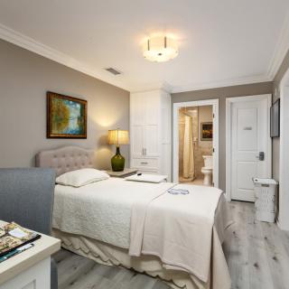 A modern bedroom with a single bed, featuring neutral tones and sleek decor.