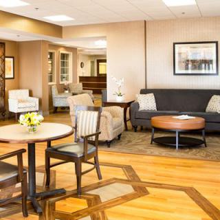 A well-furnished lobby with comfortable seating, including chairs and a sofa around a coffee table.
