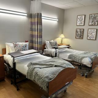 A well-furnished patient room with two beds, designed for comfort and care.