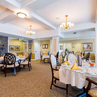 Elegant dining area with neatly arranged tables and chandeliers.
