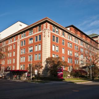 A red brick building featuring a modern architectural design, bathed in daylight.