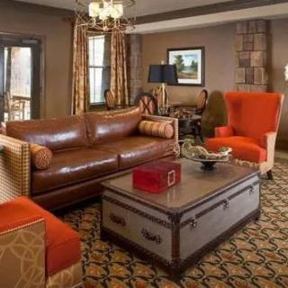 A cozy and elegantly decorated living room with leather and upholstered furniture.