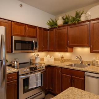 A modern kitchen with wood cabinets and stainless steel appliances.
